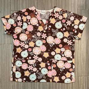 M fits like a L Tafford Scrub Top. Pretty pastels on brown! 🌸
